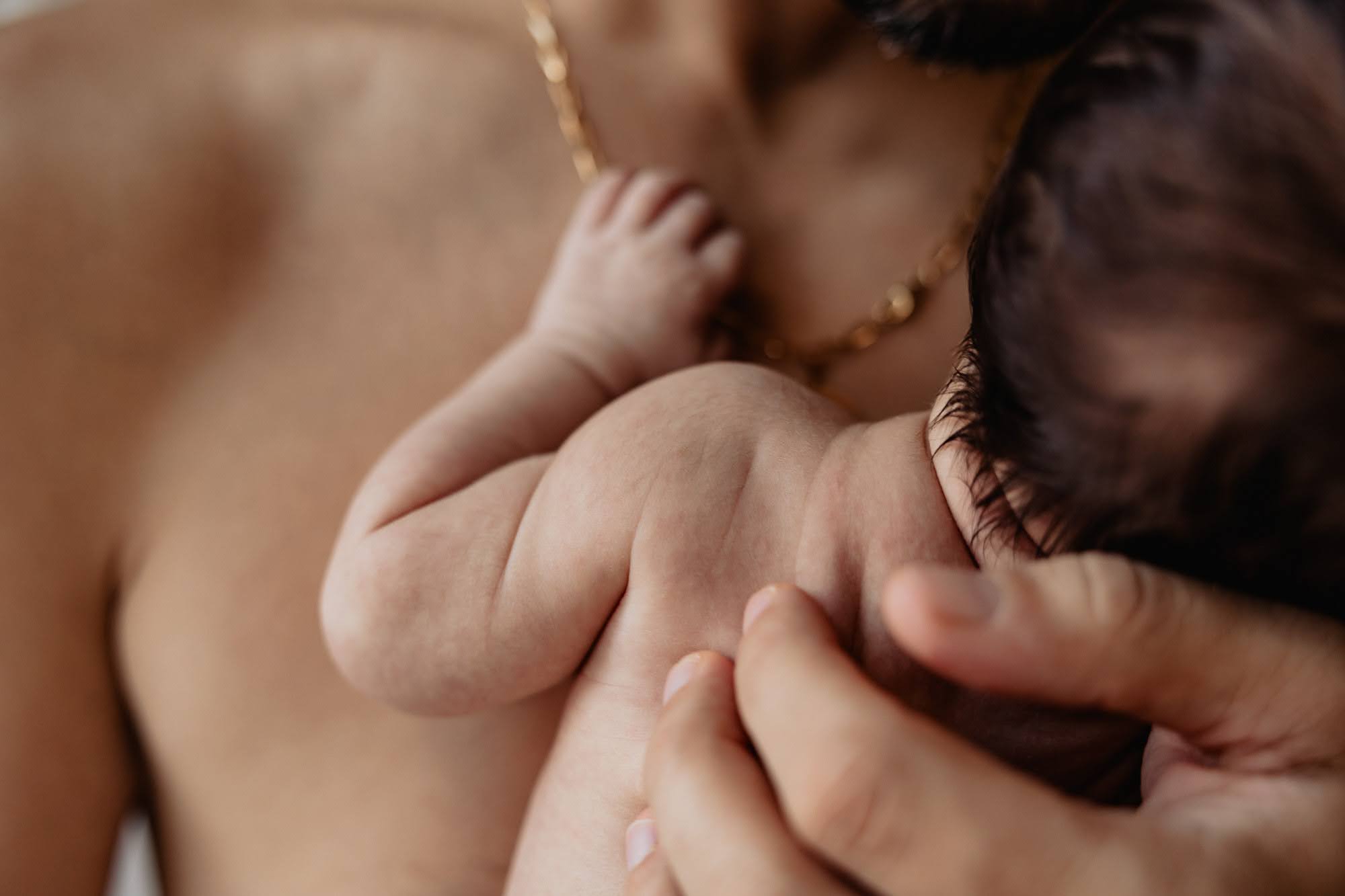 Nouveau-né en peau à peau contre son parent lors d’une séance photo naissance à domicile à Marseille