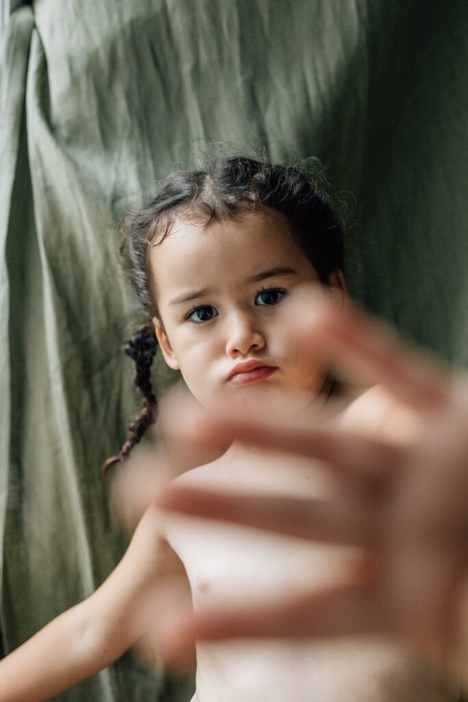 Portrait d’une petite fille fâchée, regard caméra lors d’une séance photo à domicile à Marseille