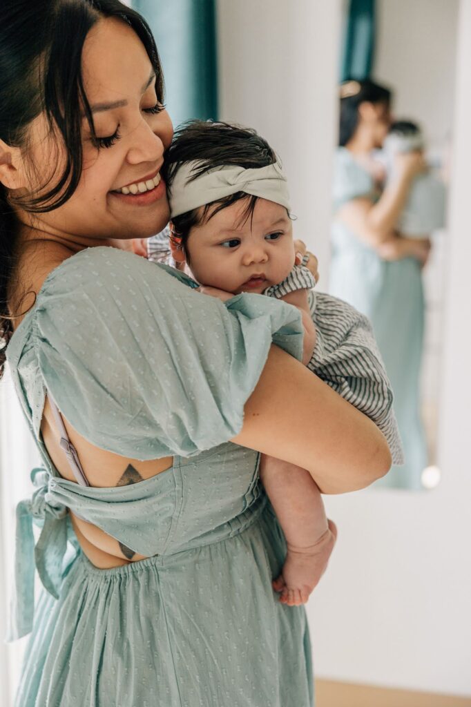 Maman portant son bébé dans les bras, séance photo famille à domicile au centre ville de Marseille