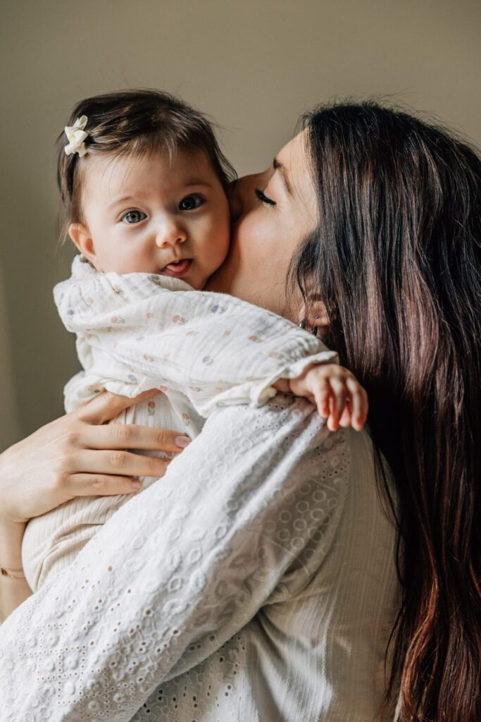 gros plan sur une maman embrassant son bébé lors d'une séance famille à domicile à Marseille