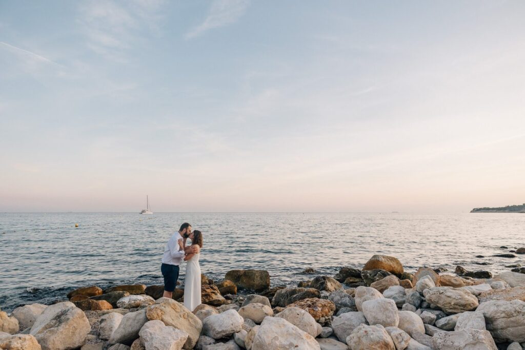 Couple enlacé sur les rochers face à la mer à Cassis au coucher du soleil