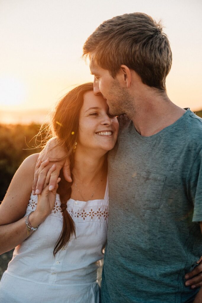 moment tendre entre un couple pendant une séance photo au coucher du soleil