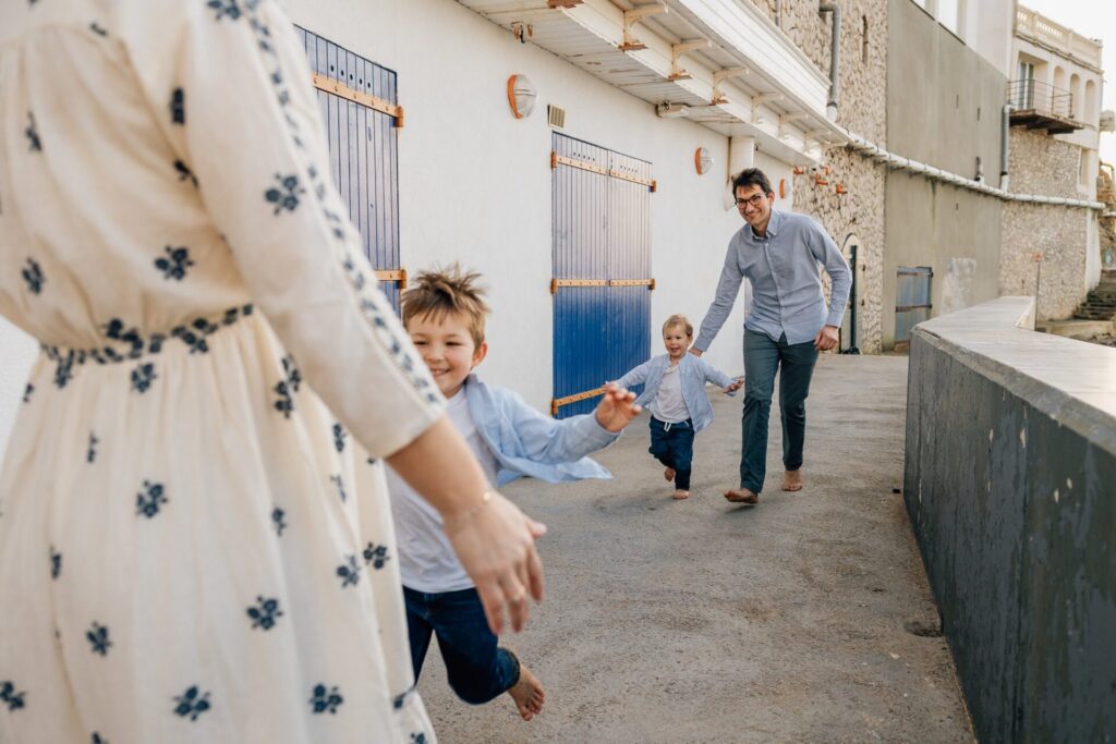 Maman et enfant courant dans une ruelle colorée à Marseille lors d’une séance photo famille à la plage des Phocéens