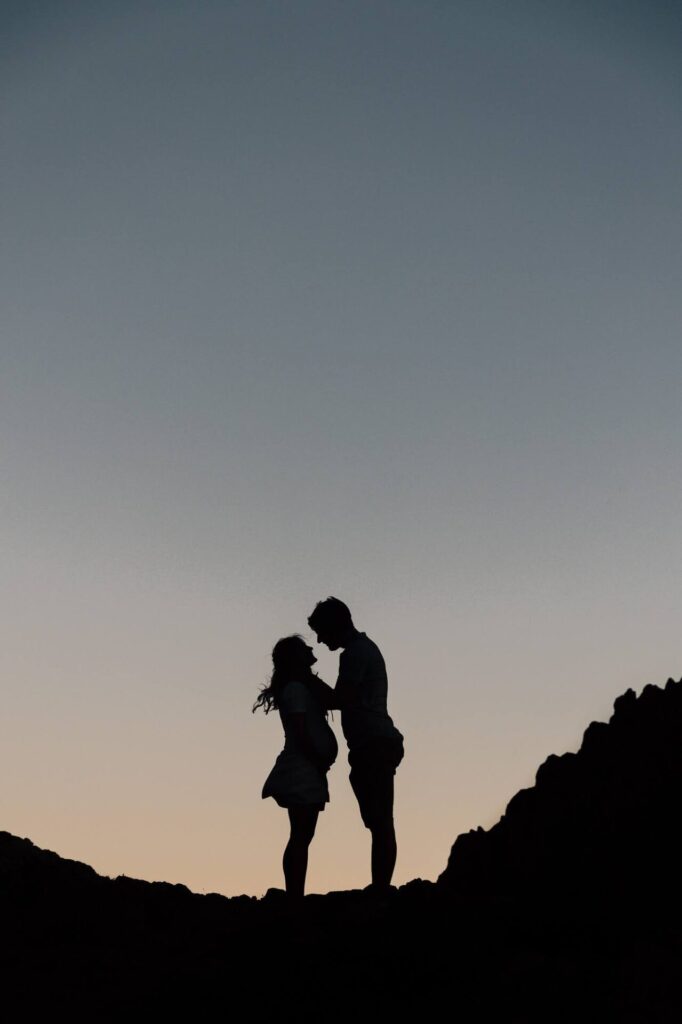 Silhouette d'un couple lors d'une séance photo de grossesse au coucher du soleil dans les calanques de Marseille 13008