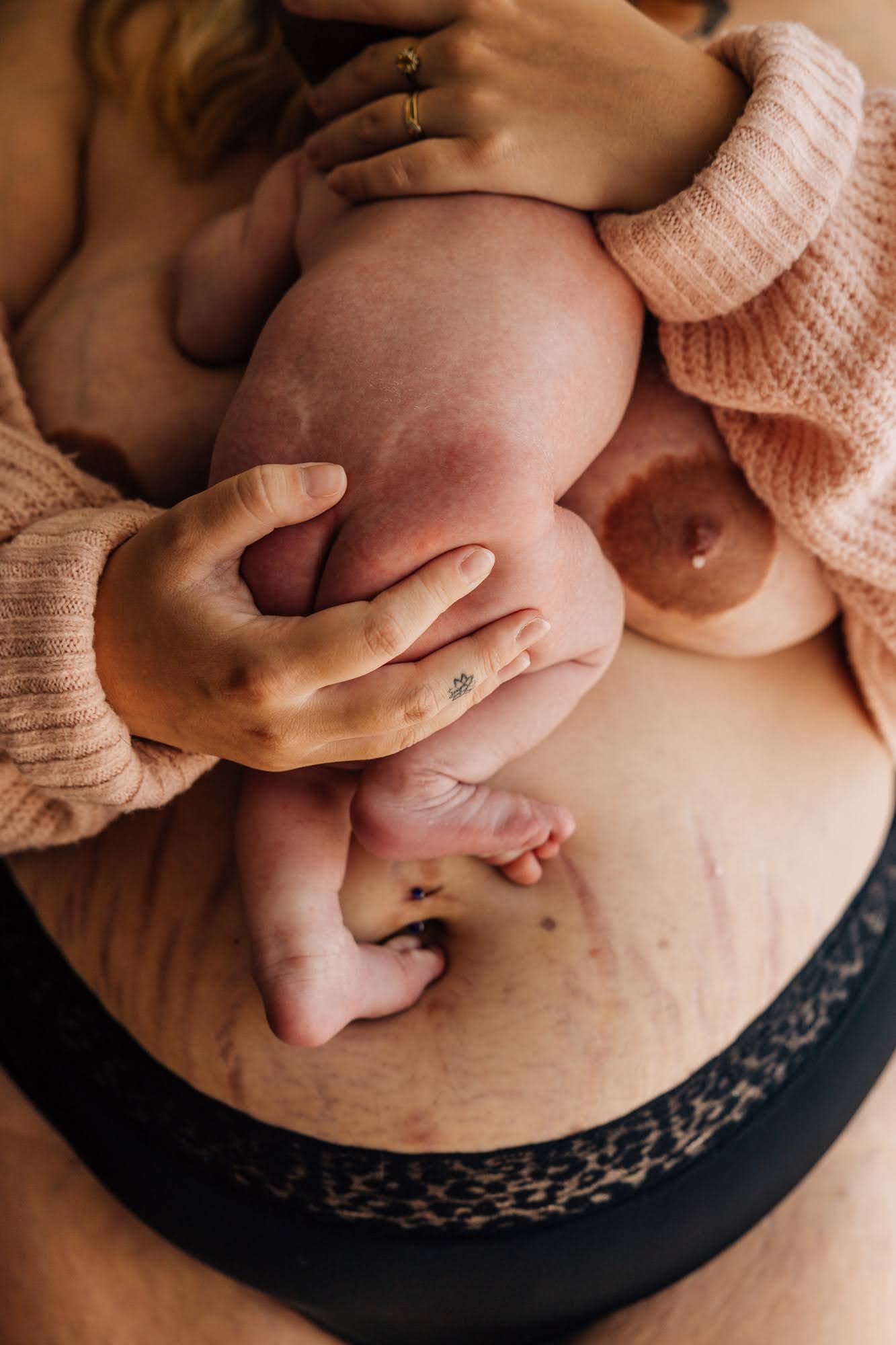 Détail d'un nouveau-né en peau à peau contre sa mère lors d’une séance photo bébé à domicile à Marseille