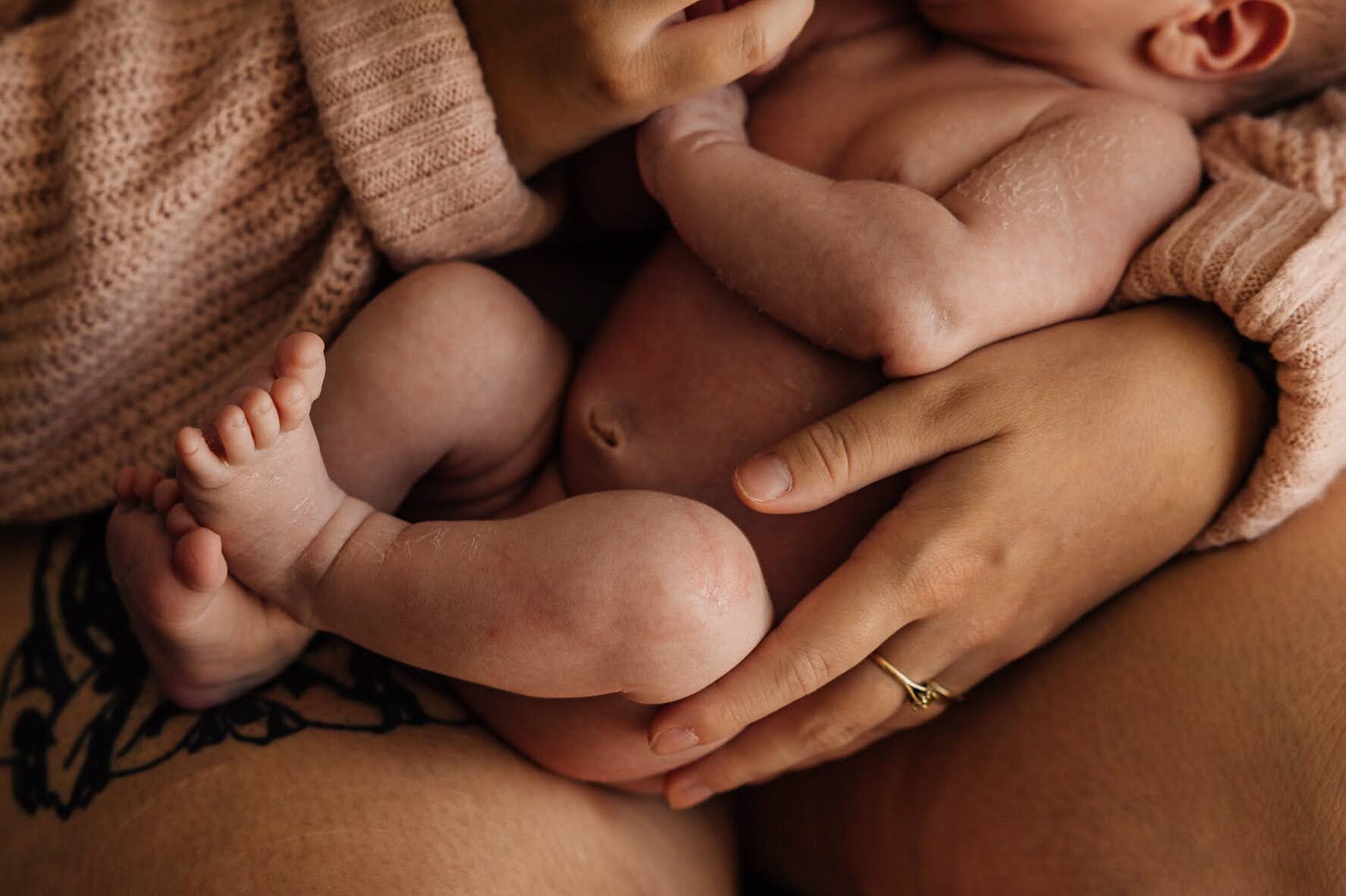 Détail du corps d’un nouveau-né en peau à peau lors d’une séance photo bébé à domicile à Marseille 13008