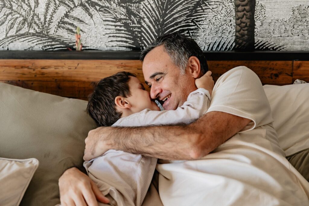 père et enfant allongés moment complice séance photo famille à domicile lumière douce
