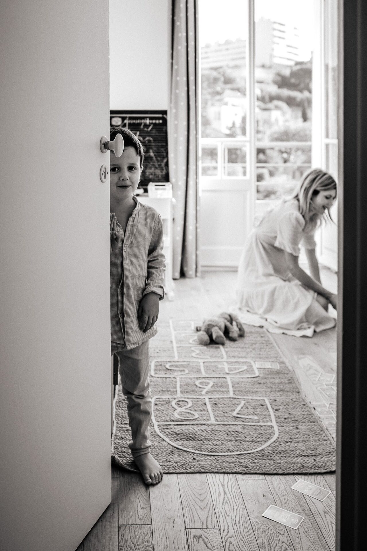 Scène de vie en noir et blanc à domicile, enfant dans un intérieur lumineux du 7e arrondissement de Marseille