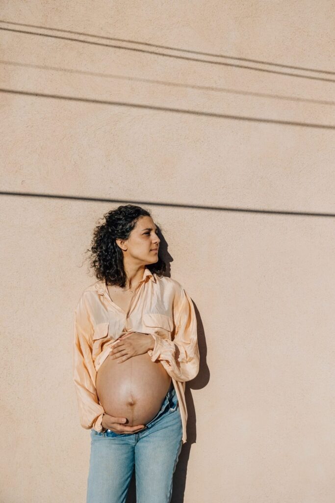 portrait de femme enceinte contre un mur lors d’une séance photo grossesse à Marseille