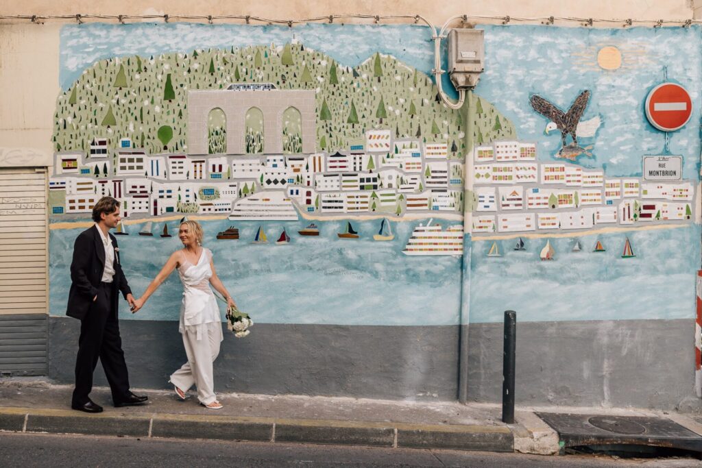 Couple se promenant devant une fresque murale dans le quartier du Panier à Marseille