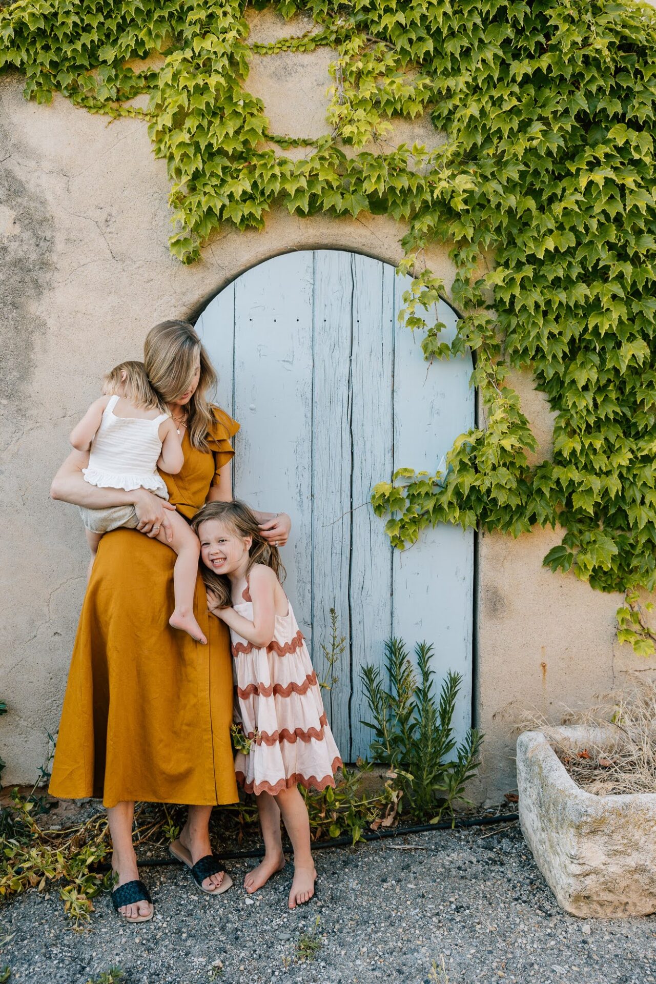 Portrait famille devant porte bleue et lierre en Provence