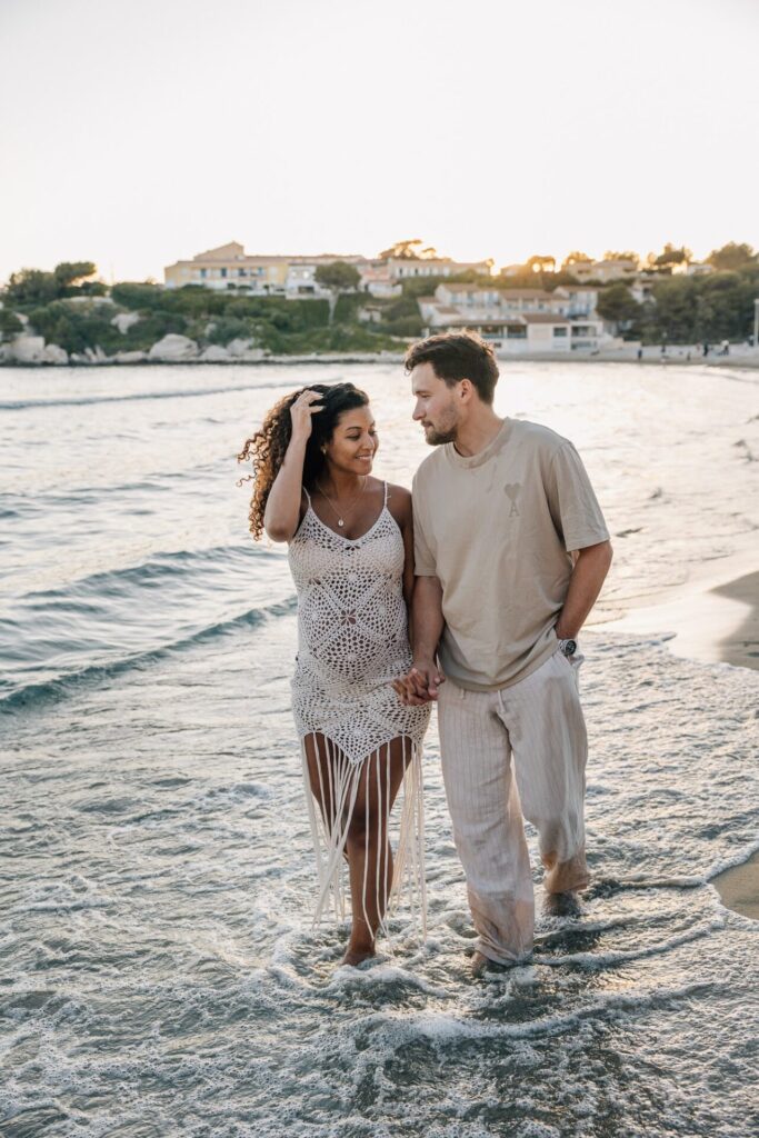 couple marchant dans l’eau pendant une séance photo grossesse à Carry-le-Rouet