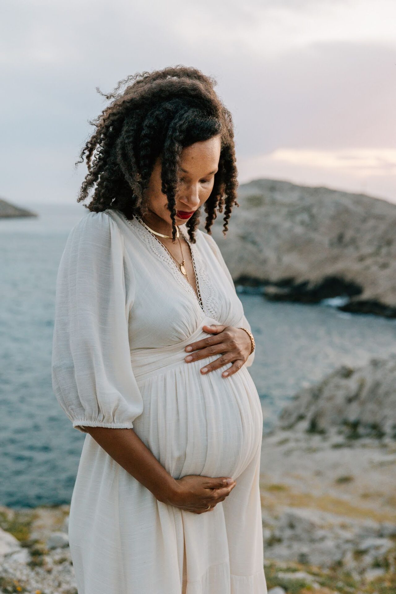 femme enceinte regardant la mer lors d’une séance photo grossesse près de Marseille