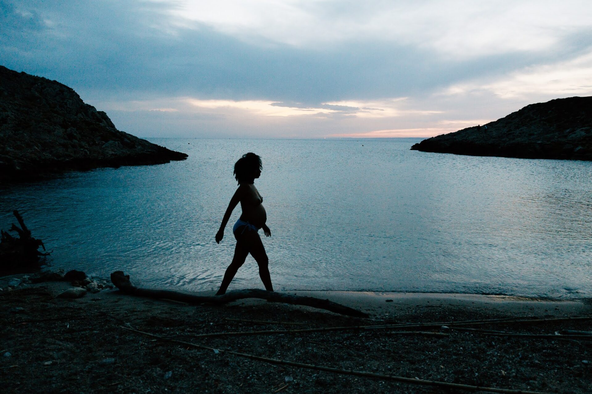 Silhouette d’une femme enceinte nue marchant face à la mer au crépuscule aux Goudes à Marseille