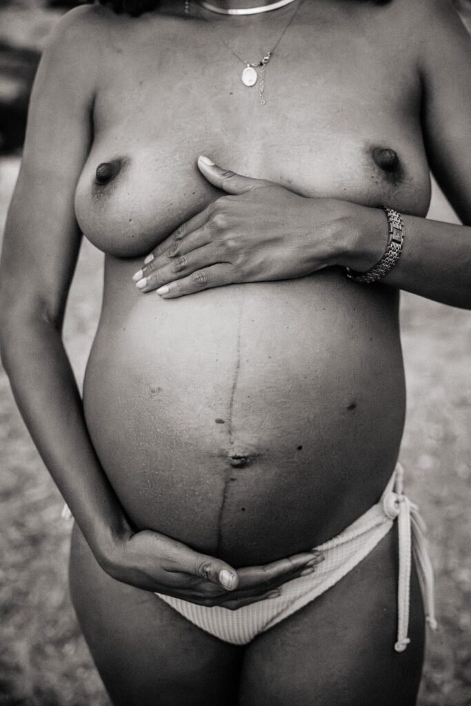 détail sur le ventre nu d'une femme enceinte à la plage pendant une séance photo de grossesse dans le 8e arrondissement de Marseille