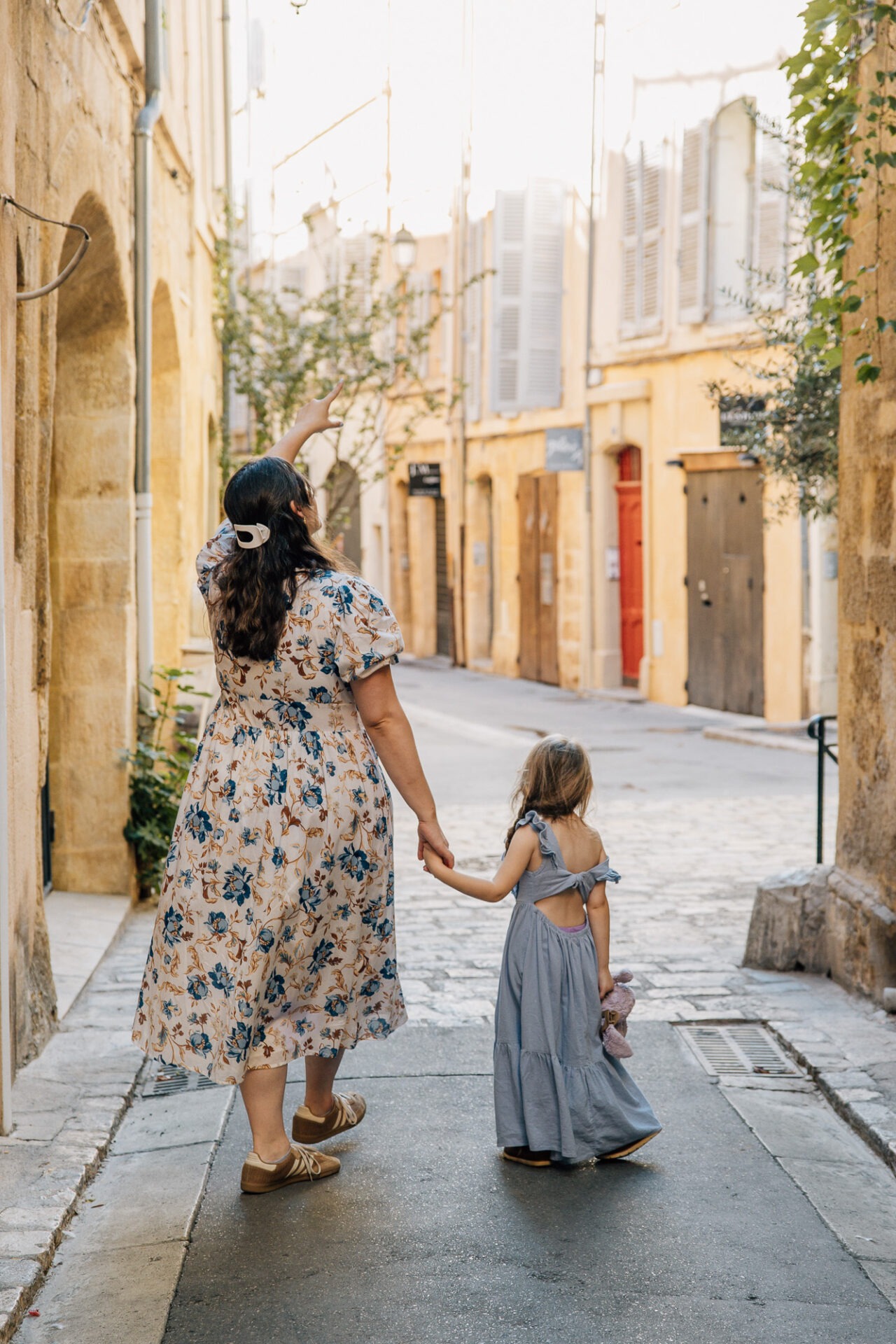 maman et enfant marchant main dans la main dans une rue d’aix en provence