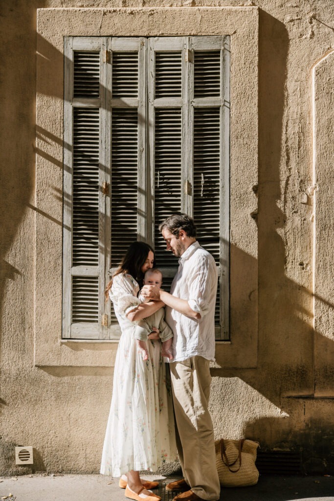 parents avec leur bébé devant une façade ancienne à Aix-en-Provence