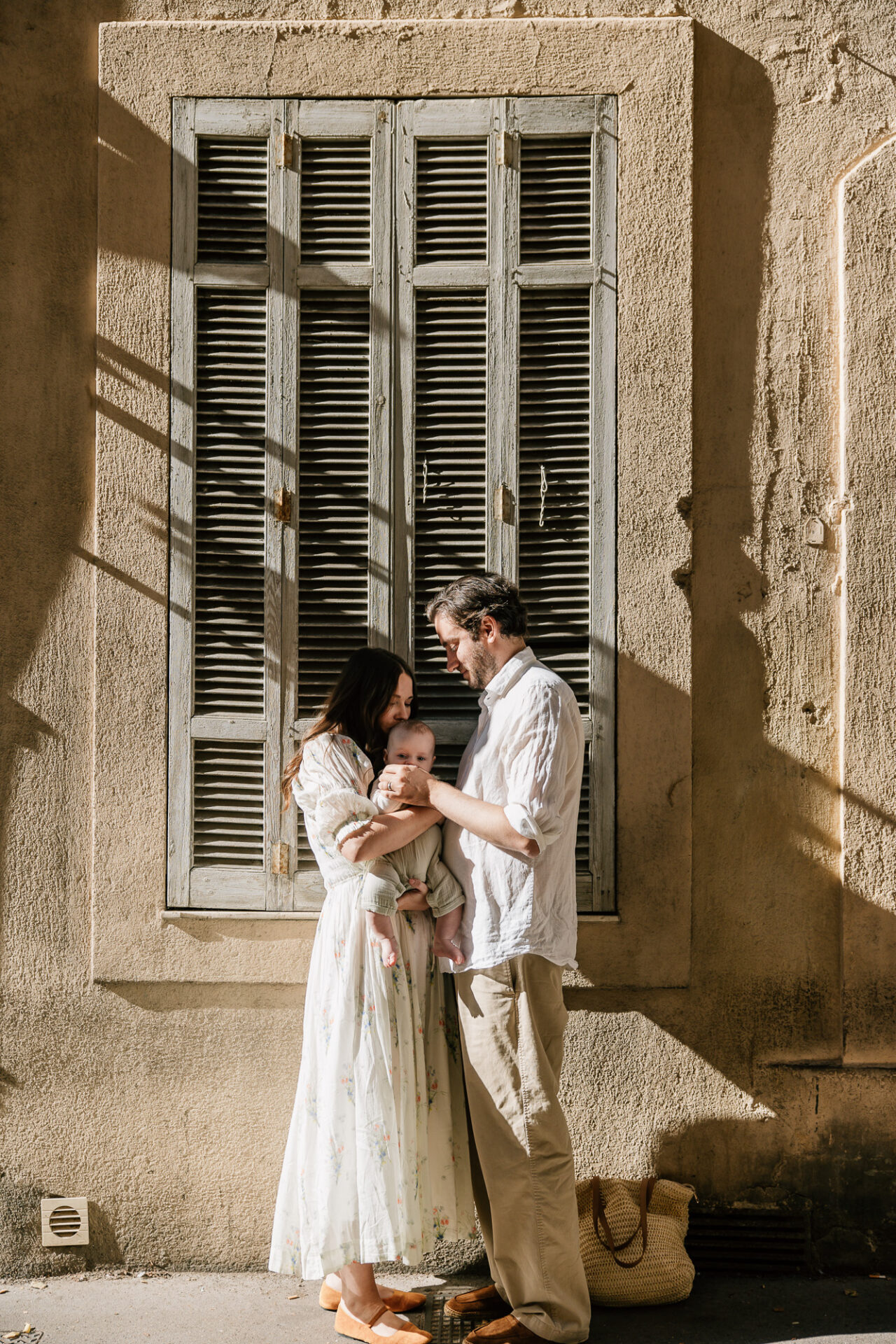 parents avec leur bébé devant une façade ancienne à Aix-en-Provence