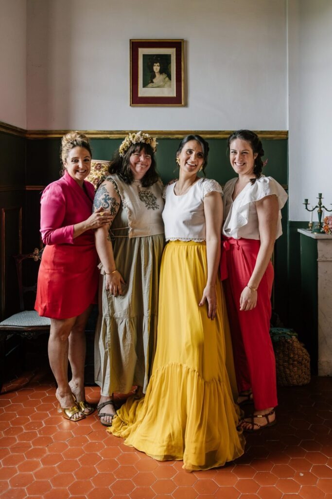 La mariée et ses témoins en robes colorées posant ensemble lors d’un mariage dans un domaine à Aix-en-Provence