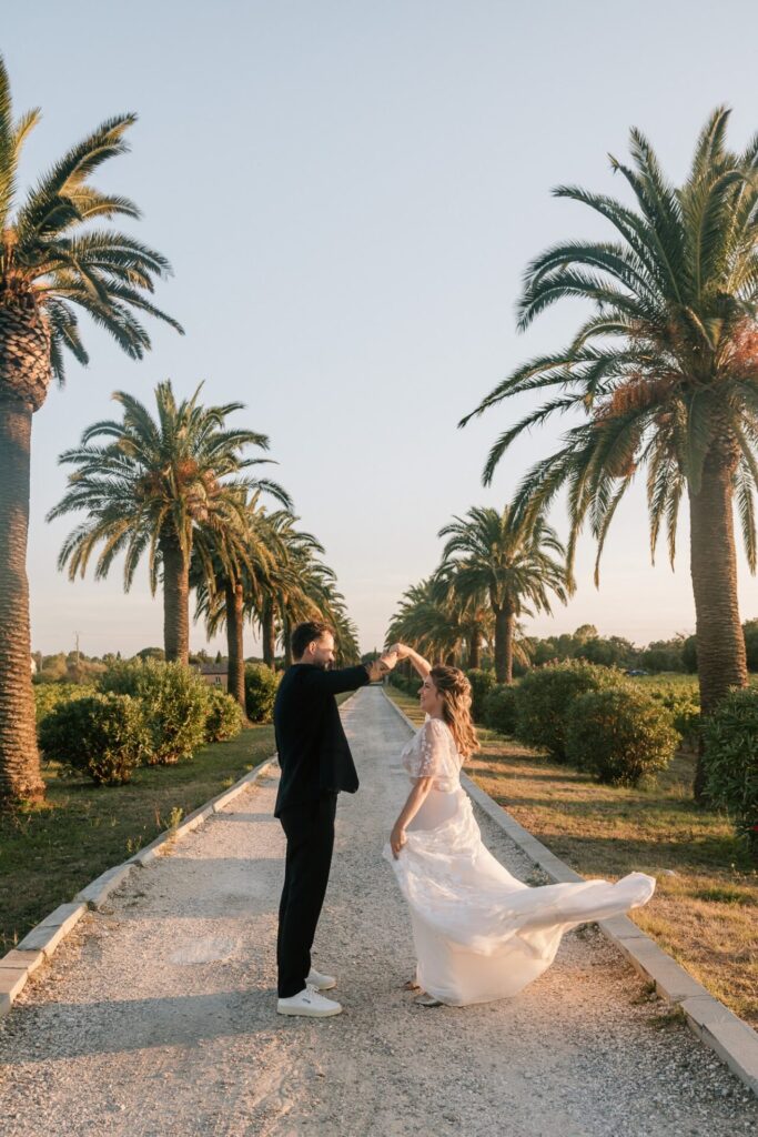 Couple dansant sur une allée bordée de palmiers, séance photo couple au château des Anglades dans le Var