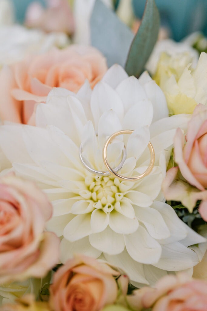 alliances de mariage posées sur un bouquet de fleurs