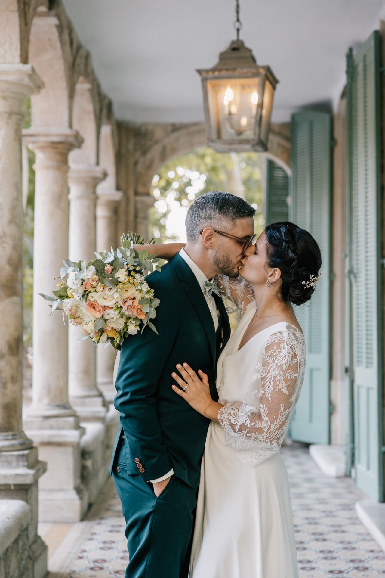 Mariés s’embrassant sous les arcades de la Bastide de Toursainte à Marseille pendant leur mariage