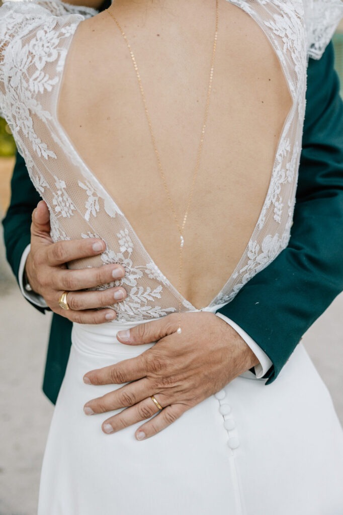 détail de la robe de mariée et des mains des mariés