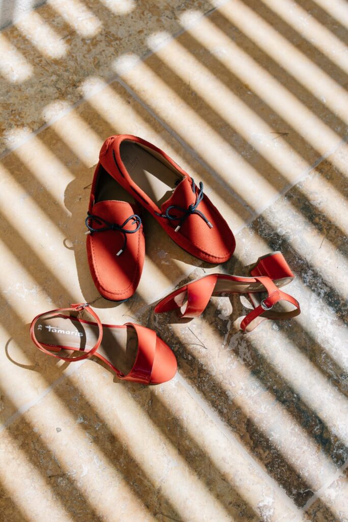 Chaussures rouges posées au sol en lumière graphique lors des préparatifs de mariage au domaine de Canaille à Cassis