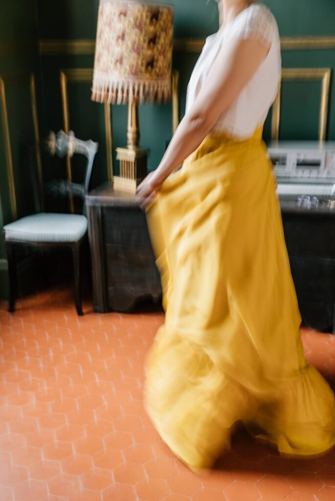 Détail d’une robe jaune en mouvement dans une pièce en intérieur dans le domaine de Lineau à Gréoux-les-Bains