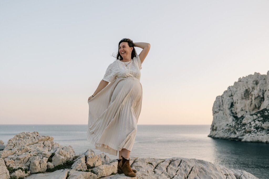 femme enceinte sur les rochers face à la mer lors d’une séance photo grossesse dans les calanques