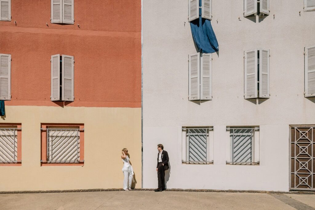 Couple de mariés face à face devant une façade colorée lors d’une séance couple dans le Panier à Marseille