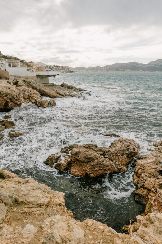 Côte rocheuse de Malmousque à Marseille, mer agitée sous ciel nuageux et lumière diffuse, atmosphère brute, un peu sauvage