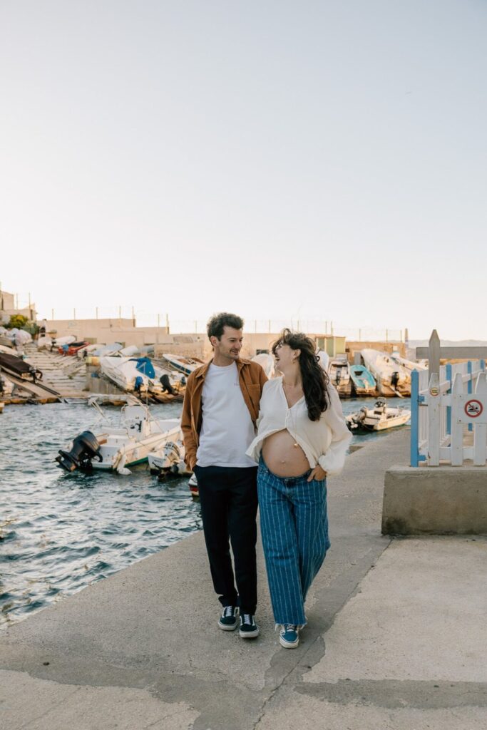 couple marchant sur le port de Malmousque pendant une séance photo grossesse à Marseille