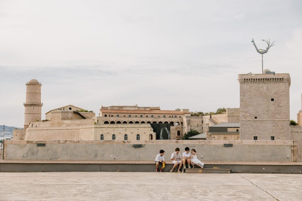 Invités assis sur le toit du Fort Ganteaume lors d’un mariage avec vue sur le Fort Saint-Nicolas à Marseille