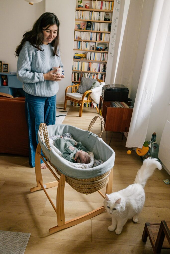 maman regardant son bébé dans un couffin séance photo nouveau-né à domicile