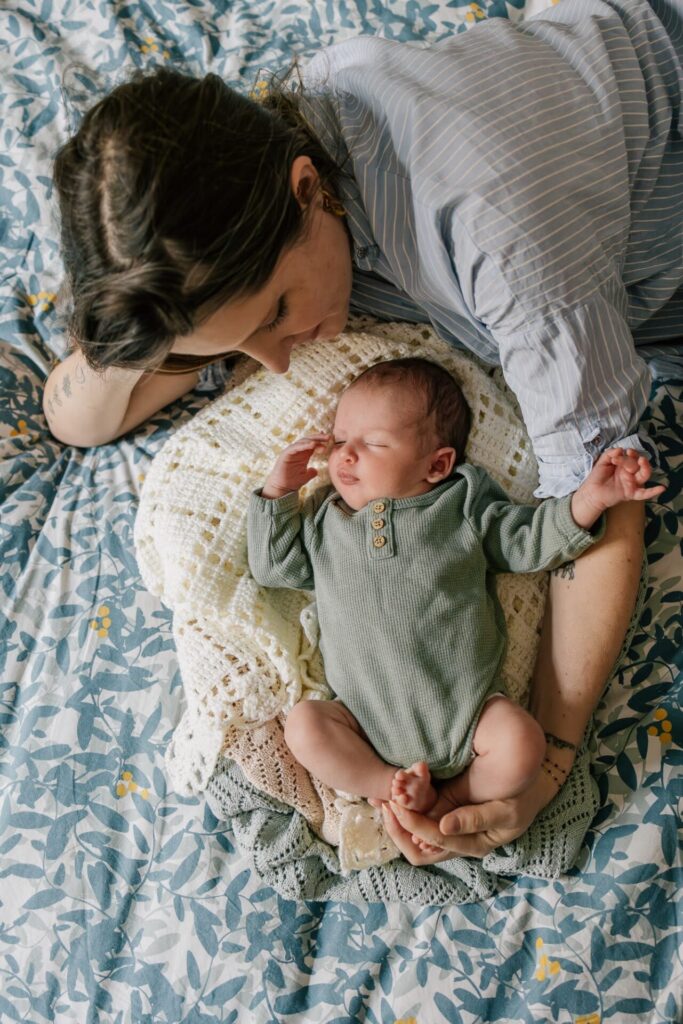 Maman allongée avec son nouveau-né lors d’une séance photo bébé à domicile à Marseille