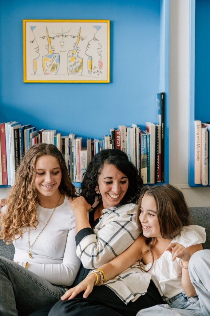 Maman et ses filles souriant lors d'une séance photo de famille dans un appartement coloré du Corbusier à Marseille