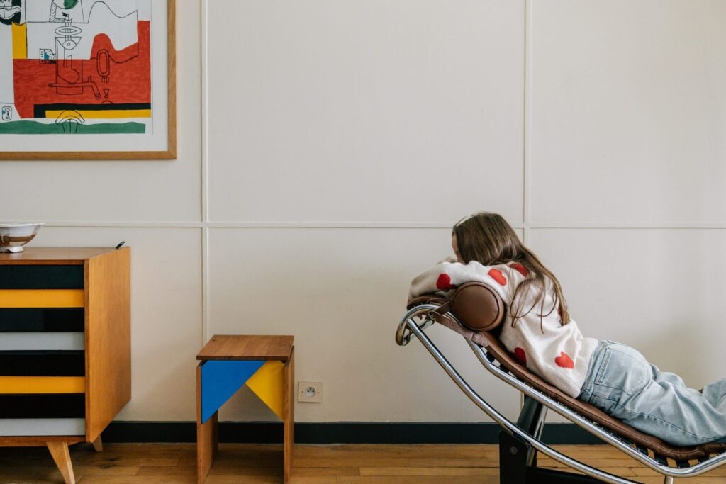 Enfant dans une chaise design dans un appartement de la Cité Radieuse du Corbusier lors d’une séance photo famille à Marseille
