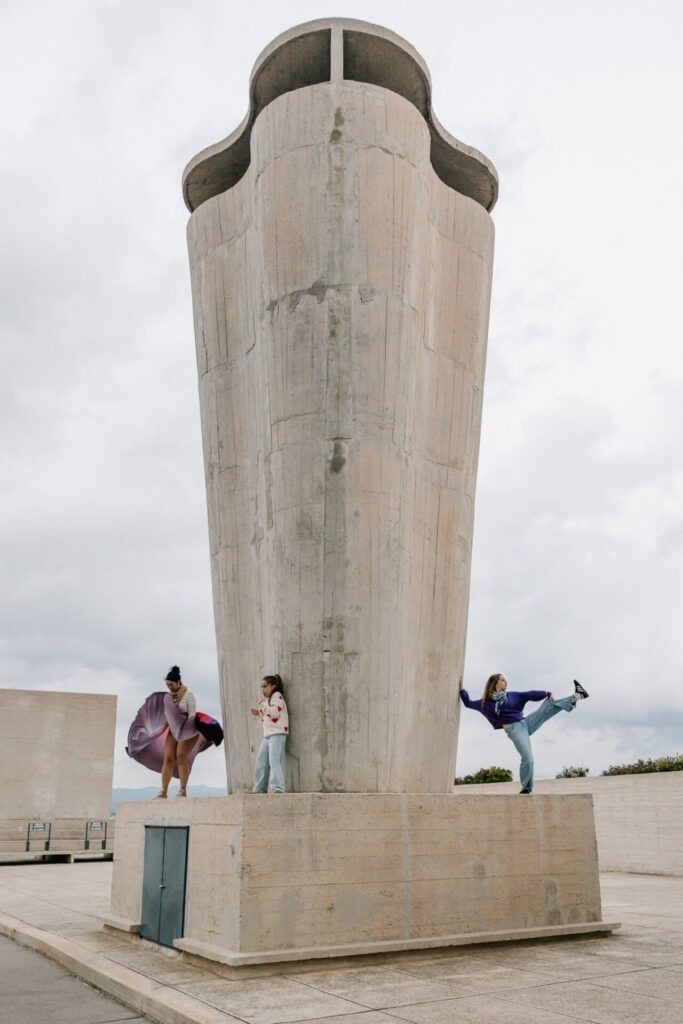Famille dansant sous une architecture en béton moderne lors d’une séance photo sur le toit du Corbusier à Marseille