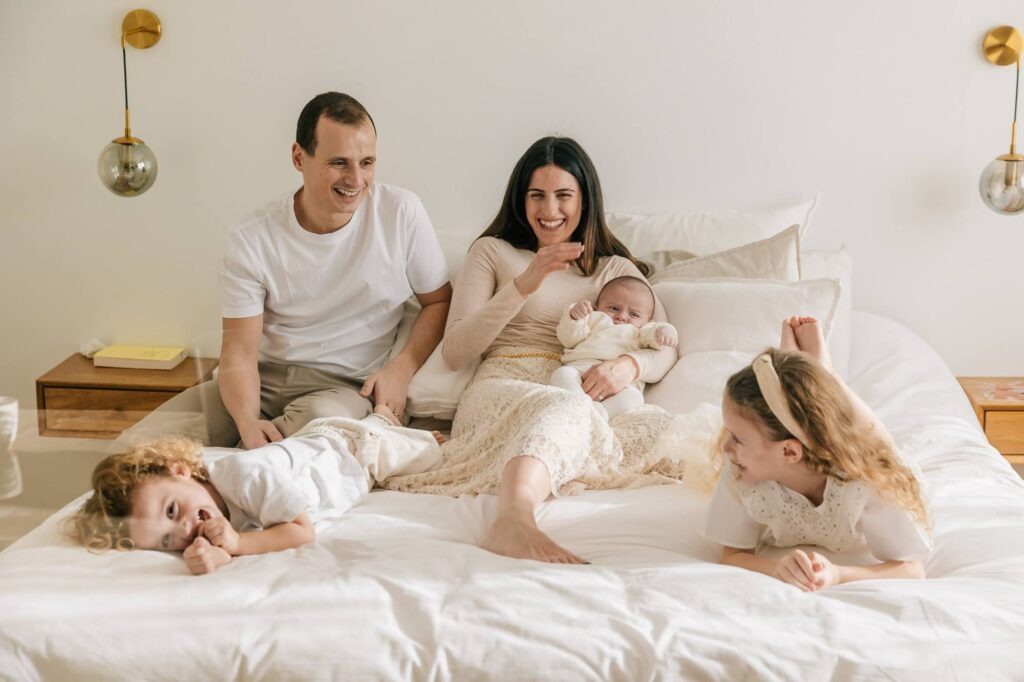 Famille avec bébé sur un lit lors d’une séance photo famille à domicile à Marseille 13007