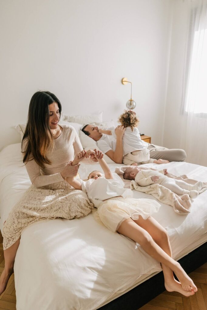 Famille avec nouveau-né sur un lit lors d’une séance photo bébé à domicile à Marseille 13007