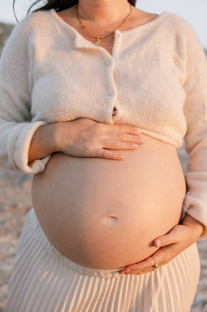 détail du ventre d’une femme enceinte lors d’une séance photo grossesse en bord de mer à Marseille