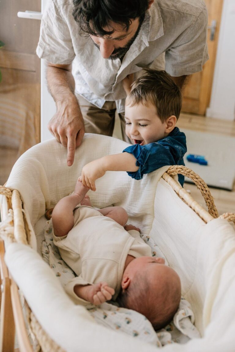Grand frère curieux qui découvre le nouveau-né dans son berceau