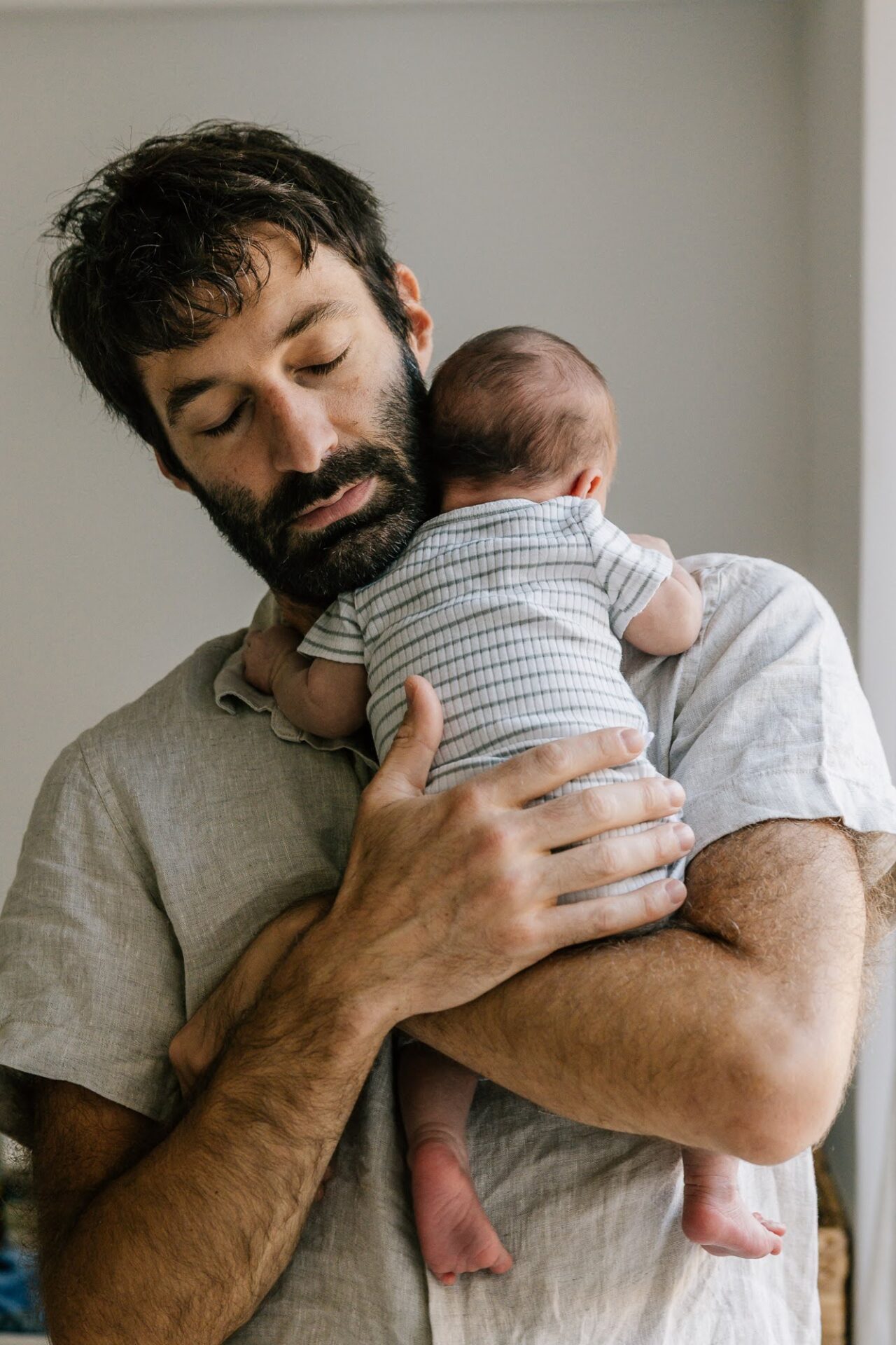 Nouveau-né contre son père lors d’une séance photo bébé à domicile à l'Estaque à Marseille
