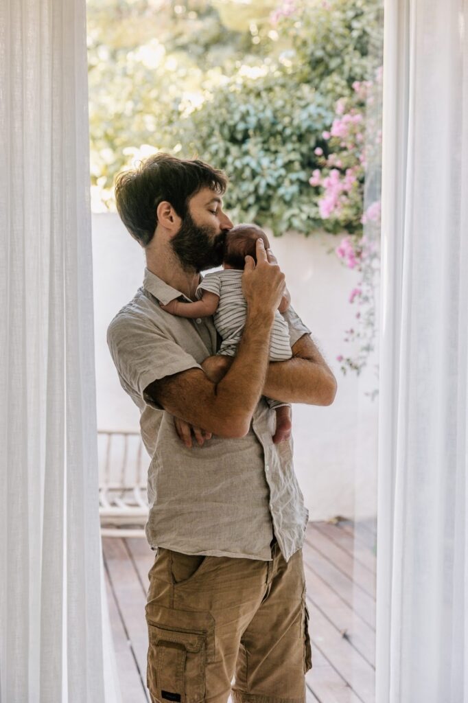 Papa avec son nouveau-né dans les bras sur la terrasse ensoleillée à Marseille