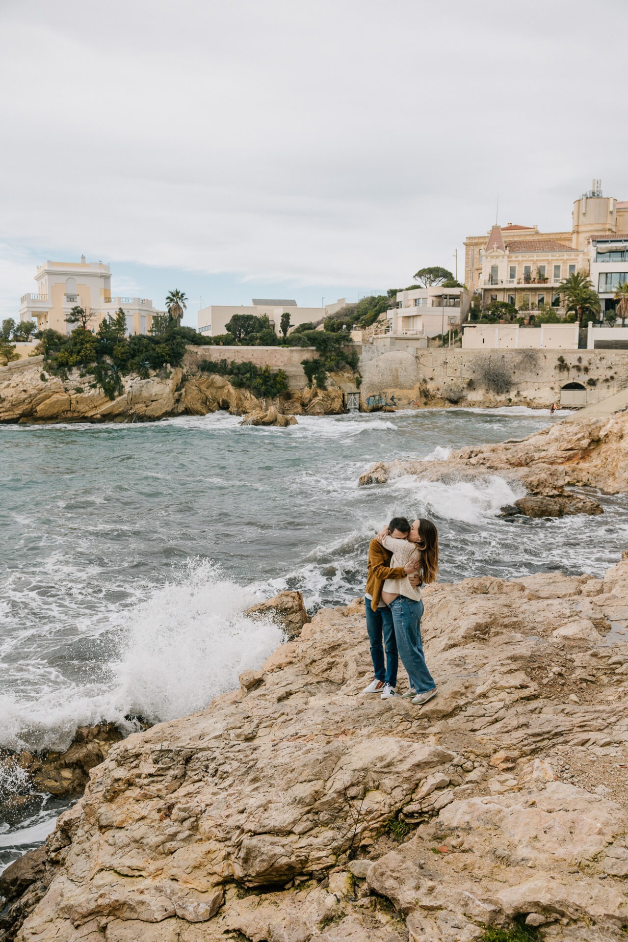 Séance grossesse en couple à Malmousque à Marseille sur les rochers en bord de mer sous le mistral
