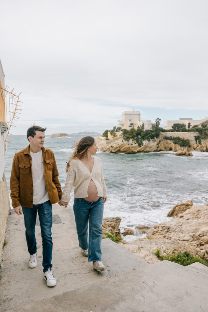 Séance grossesse à Malmousque à Marseille, couple qui marche en bord de mer