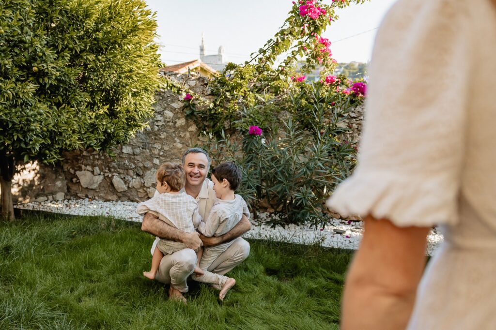 Père et enfants dans le jardin, moment complice photographié lors d’une séance famille à Marseille.