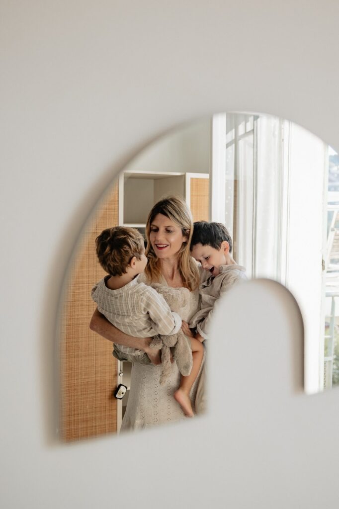 Mère avec ses enfants devant un miroir, séance photo famille à domicile dans le 7e arrondissement de Marseille.