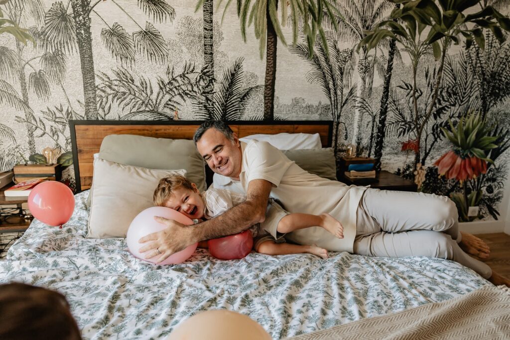 Scène de famille dans une chambre avec tapisserie, lumière naturelle, séance photo à Marseille 13007